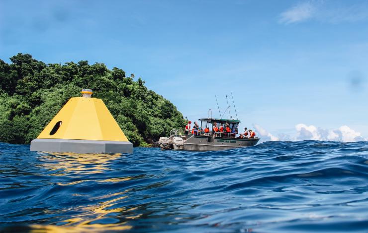 Buoy in Fagatele Bay in the NOAA National Marine Sanctuary of American Samoa with partner ship in the background.. 