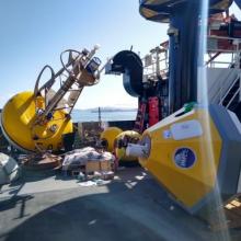 Two yellow buoys on a ship deck on a clear blue sky day