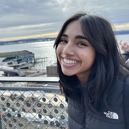 Anjali standing outdoors with dock and water in background