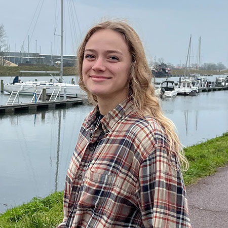 Tay in front of sidewalk and dock lined with small boats